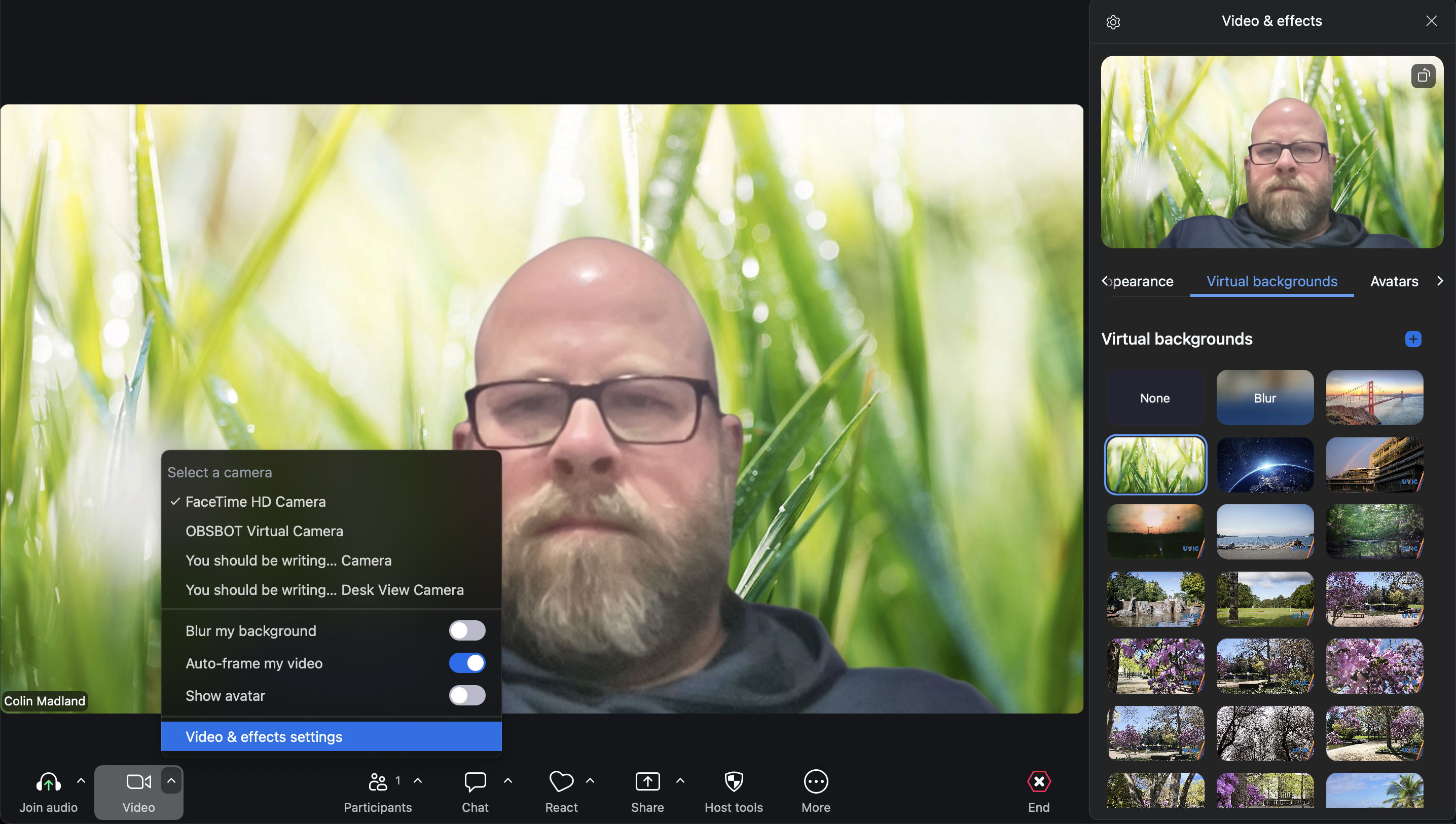 Colin in a Zoom session with an image of bright green grass replacing his background.